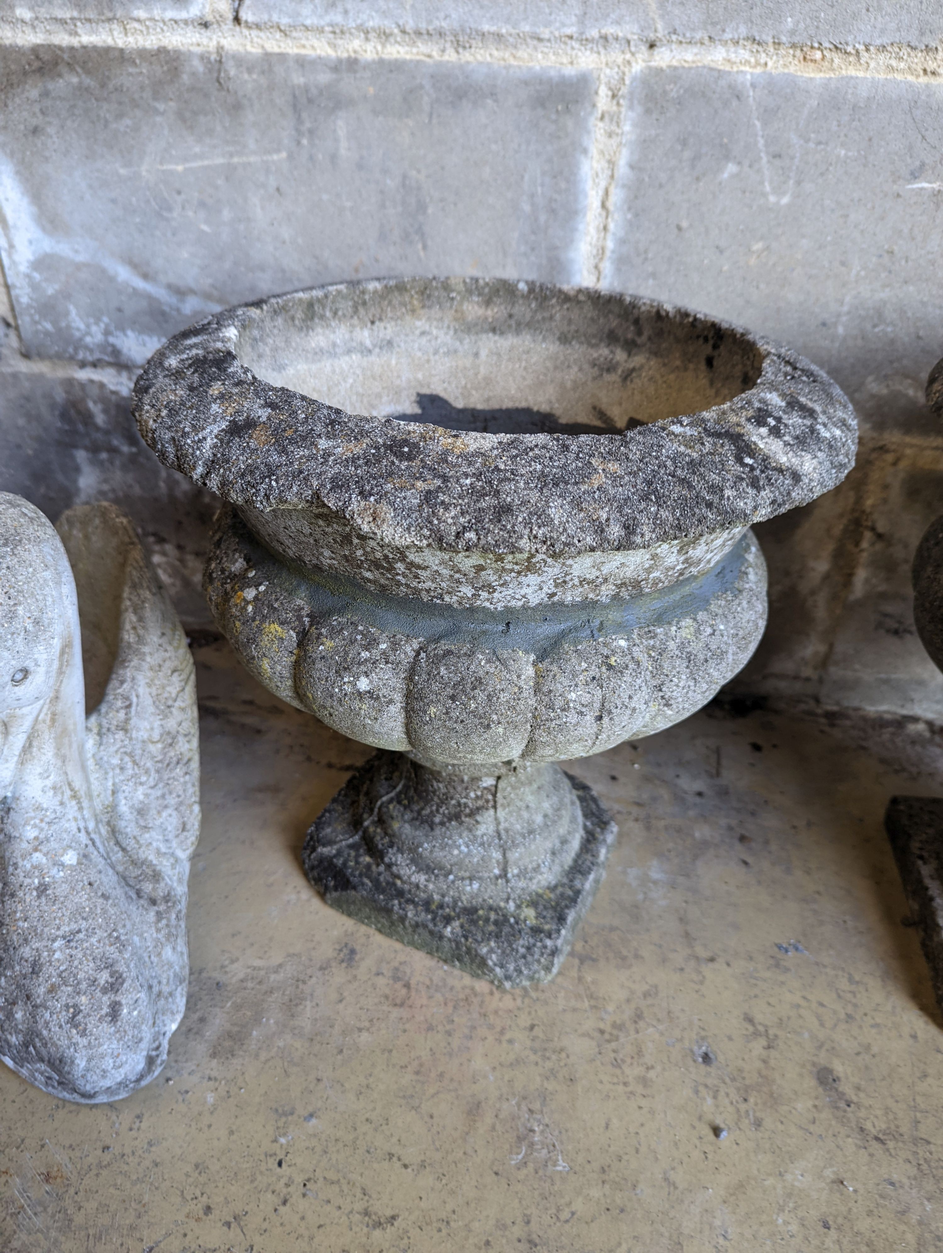 A pair of reconstituted stone circular campana garden urns, diameter 34cm, height 36cm